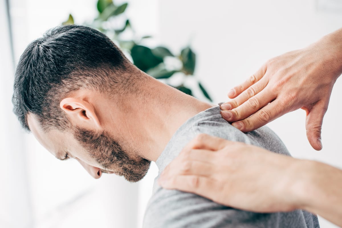 Chiropractor's hand on a patient's neck during an adjustment