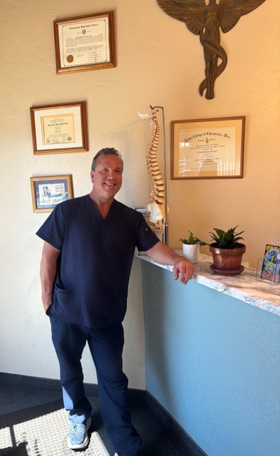Hands demonstrating spinal alignment on an anatomical spine model